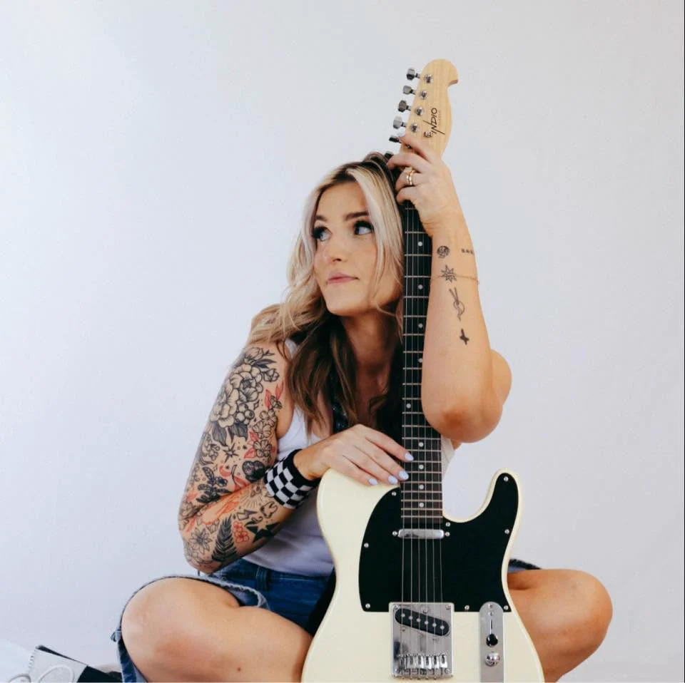 Grace Graber holding a cream electric guitar