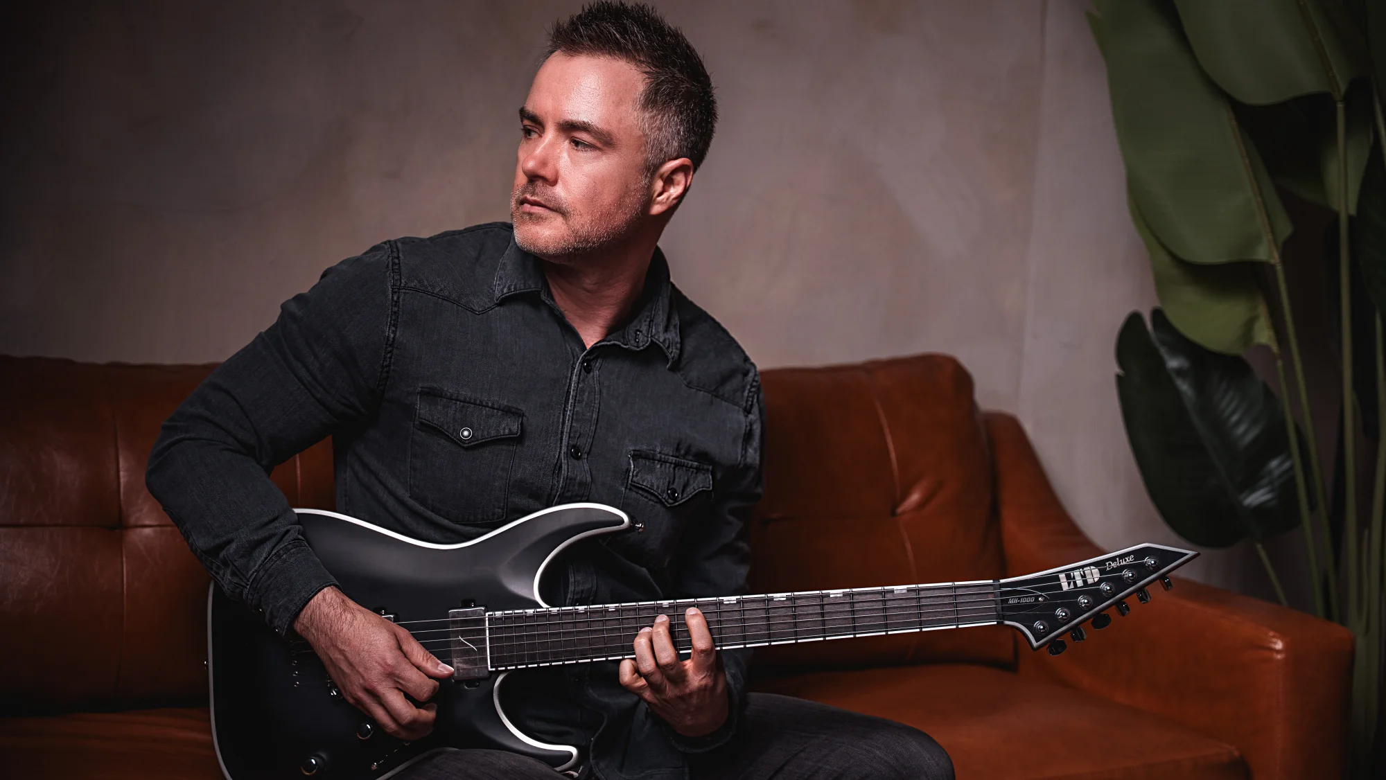 Bill Branstetter of Out of the Depths seated with a black electric guitar