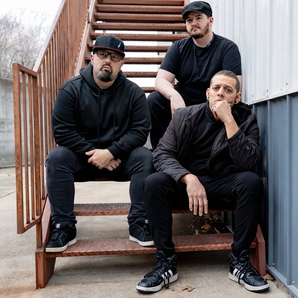 XIII Minutes seated together on an outdoor staircase
